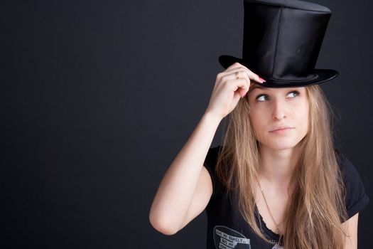 beautiful smiling girl in a black hat on a dark background