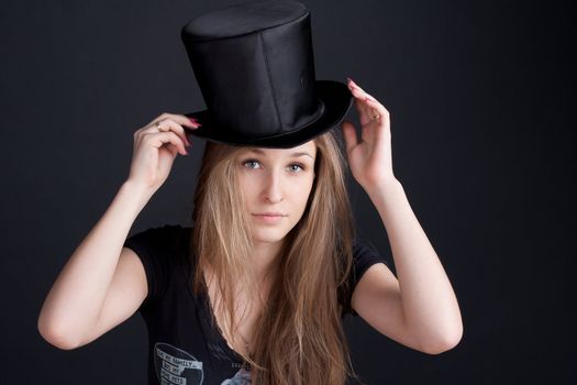 beautiful smiling girl in a black hat on a dark background