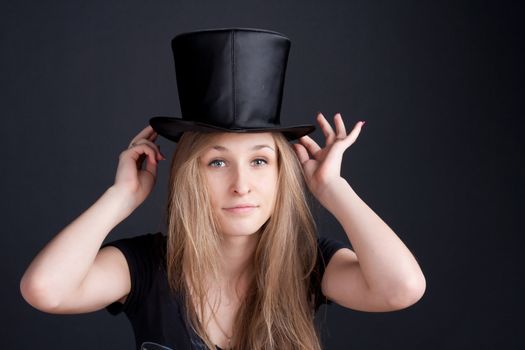 beautiful smiling girl in a black hat on a dark background