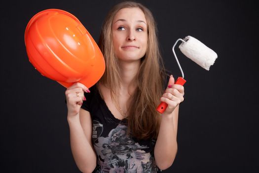 girl with a puzzled expression on his face holding a orange helmet and cushion