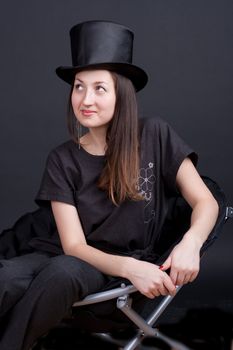 beautiful smiling girl in a black hat on a dark background