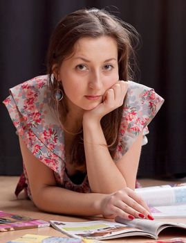 Woman lying on the floor reading magazines studio photography