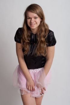 Young girl in a pink skirt on a light background