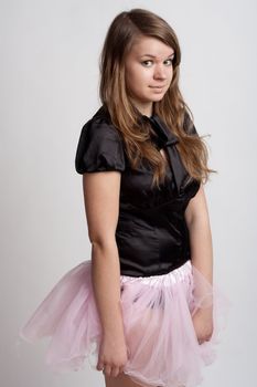 Young girl in a pink skirt on a light background