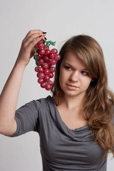 girl on a white background with grapes in his hand
