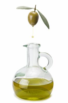 A drop of olive oil falling from one olive into a bottle