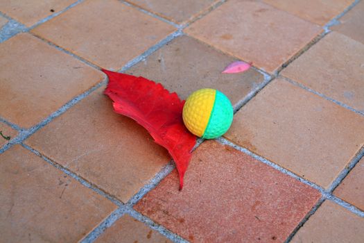ball near red sheet on tiled floor