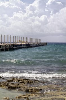 A long pier going out in the tropical ocean