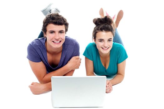 Teen friends enjoying video on laptop together. Studio shot