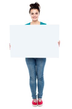 Full length portrait of stylish girl presenting banner ad isolated against white