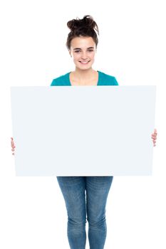 Adorable smiling teenager holding big ad board. Isolated on white