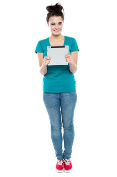 Full length portrait of pretty girl holding tablet pc. Isolated on white