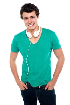 Cool trendy teenager boy with headphones around his neck. Posing casually and smartly