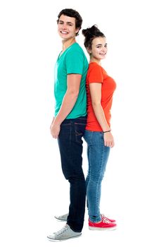 Full length portrait of an adorable young couple posing back to back