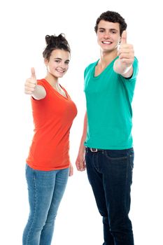 Smiling teen love couple showing thumbs up to camera together