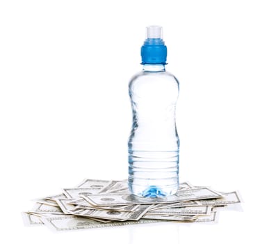 Bottle of water on heap of dollars isolated on a white background