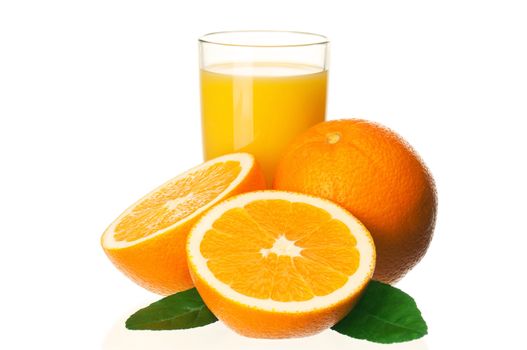 Glass of fresh orange juice and orange fruits with green leaves on white background