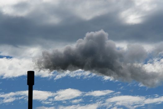 smoke coming out of a chimney against cloudy sky smoke coming out of a chimney against cloudy sky