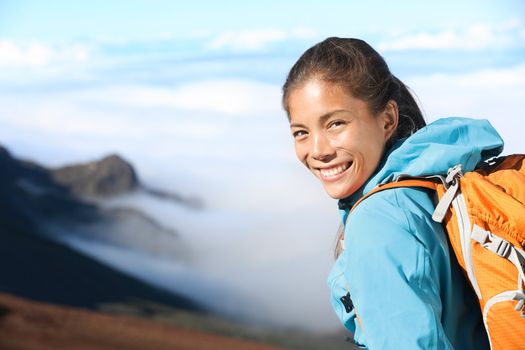 Hiker portrait of young woman hiking in high mountains. Beautiful blissful serene smiling happy mixed race Asian / Caucasian woman outdoors in big nature.