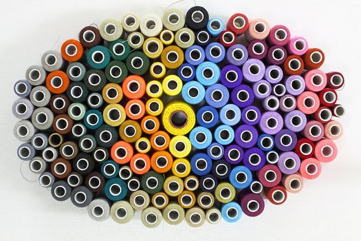 Many colorful spools of thread on a light background