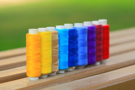 Many colorful spools of thread in a row