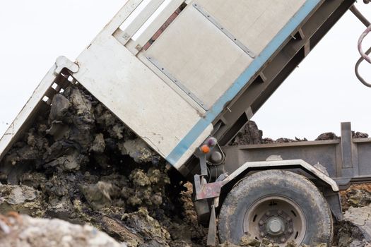 Dump truck dumping soil and dirt in the  construction site