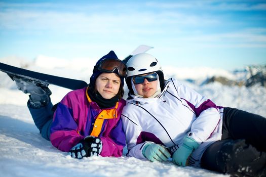 Young female skiers relaxing in the snow