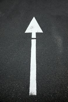 Arrow sign on asphalt surface