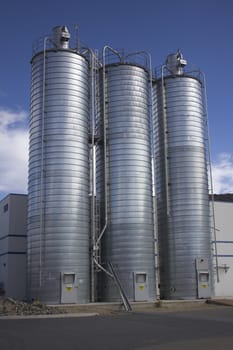 Business office or factory with silos on the side in an industrial parkway