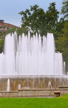 A great fountain in the green with trees