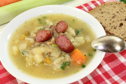 fresh white cabbage soup with vegetables, fried sausage and bread