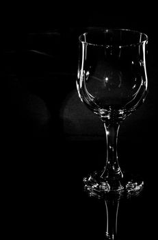 Wine glass on a black background with reflection on glass