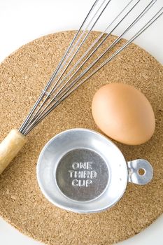 measuring on third cup with egg and whisk