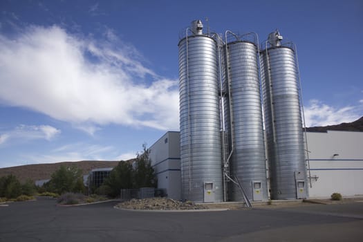Business office or factory with silos on the side in an industrial parkway