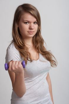 girl on a white background with dumbbells in hand