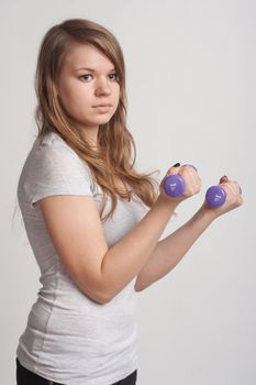 girl on a white background with dumbbells in hand