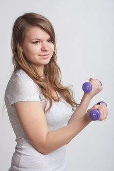 girl on a white background with dumbbells in hand