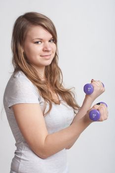 girl on a white background with dumbbells in hand