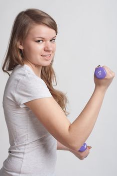 girl on a white background with dumbbells in hand