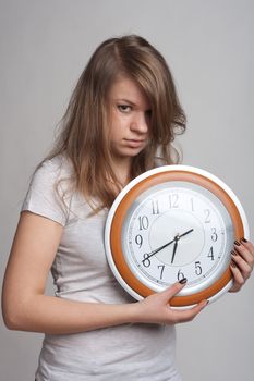 sleeping girl on a white background with a big clock in the hands of which 6.40 am