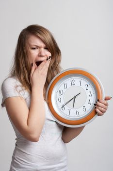 sleeping girl on a white background with a big clock in the hands of which 6.40 am