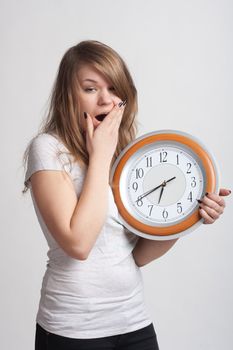 sleeping girl on a white background with a big clock in the hands of which 6.40 am