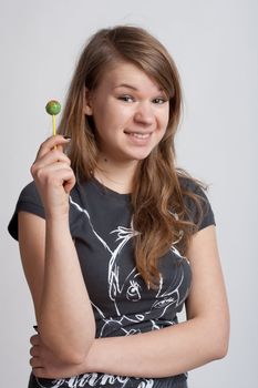 girl on a white background with candy on a stick in his hand