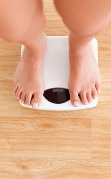 Portrait of feminine legs on a weighing machine