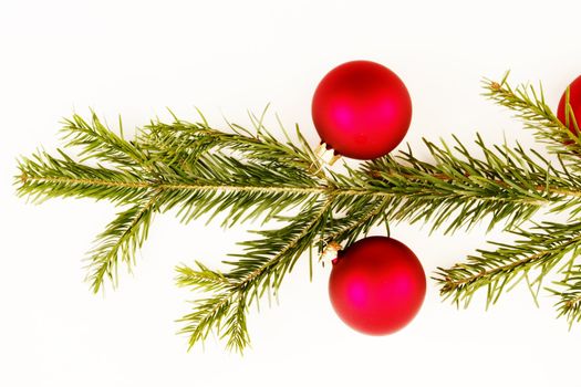 Border of red christmas garland with baubles and ribbons on white.