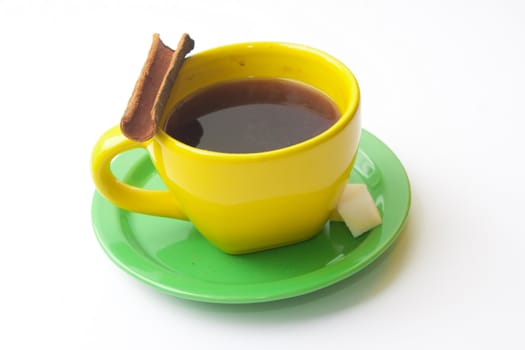 Yellow coffee cup on a green saucer, cinnamon and sugar