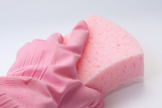 Hand in a pink rubber glove holding a pink sponge