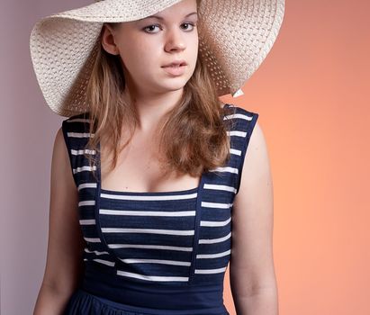 A girl in a straw hat, studio shot