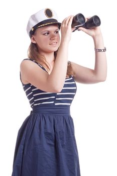 A girl in a sailor cap looks through binoculars on a white background