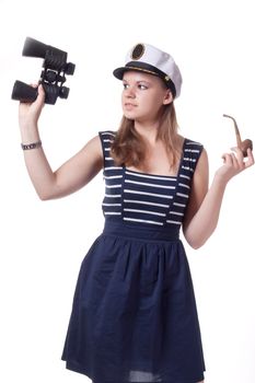 A girl in a sailor cap holding a pair of binoculars and a pipe for smoking on a white background